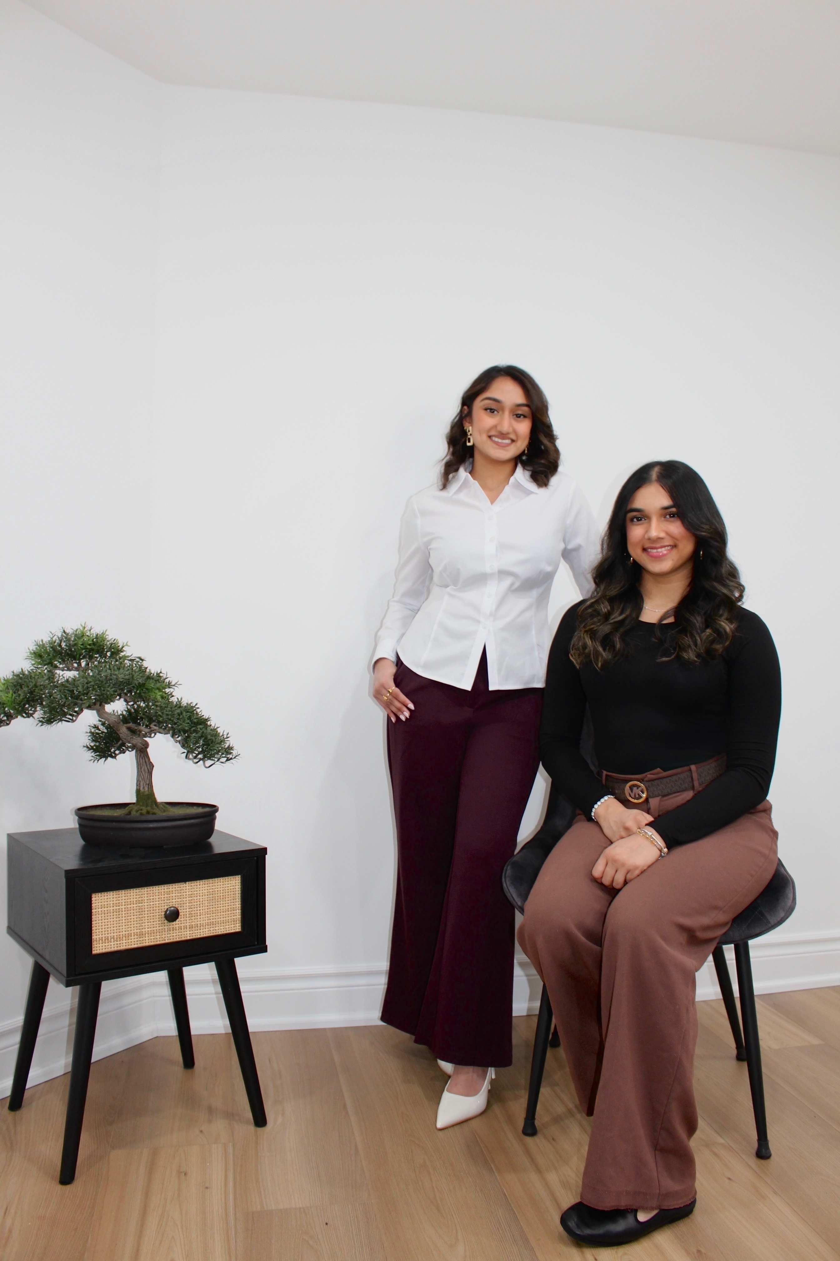 The two founders of Balance and Beyond in their studio beside a bonsai tree